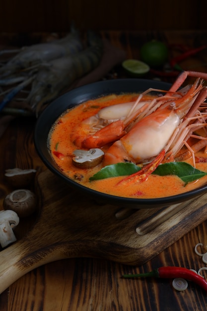 Kurzer Schuss von Tom Yum Goong mit Garnelen und scharfer würziger Suppe in schwarzer Schüssel