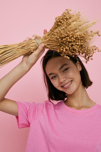 Kurzhaarige Brünette ein Bouquet von getrockneten Blumen rosa T-Shirt Lifestyle unverändert