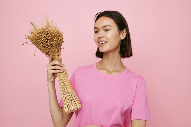 Kurzhaarige brünette rosa T-Shirts Blumenstrauß aus getrockneten Blumen isolierter Hintergrund