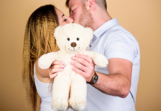 Kuscheltier Teddybär Geschenk. Kerl und Mädchen kuscheln. Glückliche Familie. Valentinstag Urlaub. Schwangerschaft-Konzept. Mann und Frau verliebt sich. Zukünftige Eltern. Familienliebe. Mann und hübsches Mädchen verliebt.