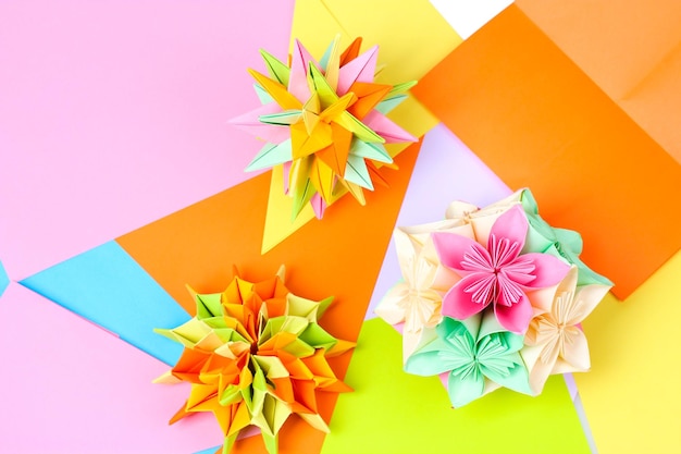 Kusudamas de origami de colores en un fondo de papel brillante