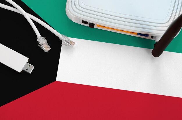 Kuwait Flagge auf dem Tisch mit Internetkabel, WLAN-WLAN-Adapter und Router abgebildet. Internetverbindungskonzept