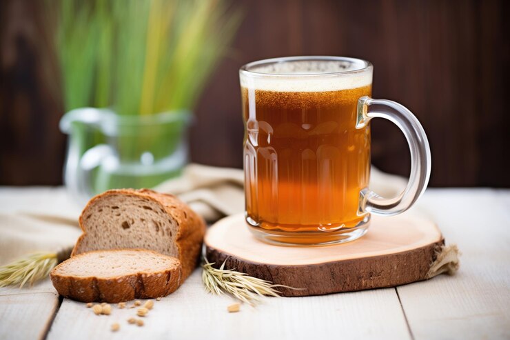 Kvas de centeno rústico en taza de vidrio con pan de centeno al lado