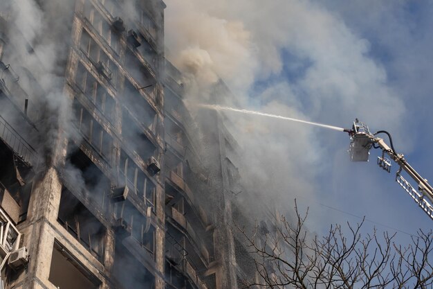 KYIV UCRANIA 15 de marzo de 2022 Guerra en Ucrania Bomberos combatiendo un incendio en un edificio residencial que fue alcanzado por un proyectil ruso