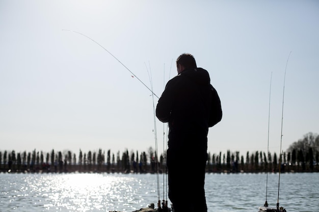 Kyiv, Ucrânia, 16 de abril de 2018. Pescador caucasiano pega peixe com uma vara de fiação no lago.