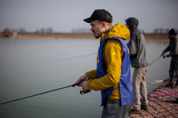 Kyiv, Ucrânia, 16 de abril de 2018. Pescador caucasiano pega peixe com uma vara de fiação no lago.