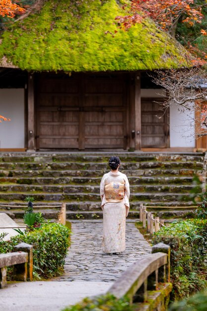 Kyoto, Japón Una mujer con kimono en el templo de Honenin el jardín de hojas de otoño los árboles de arce se vuelven rojos