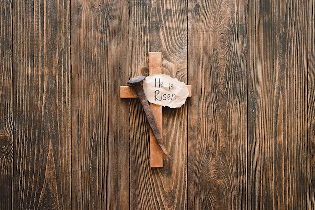 Él es Jesús Resucitado Corona Espinas y clavos y cruz sobre un fondo de madera Crucifixión de Jesucristo Pasión de Jesucristo Concepto de fe espiritualidad y religión Día de Pascua