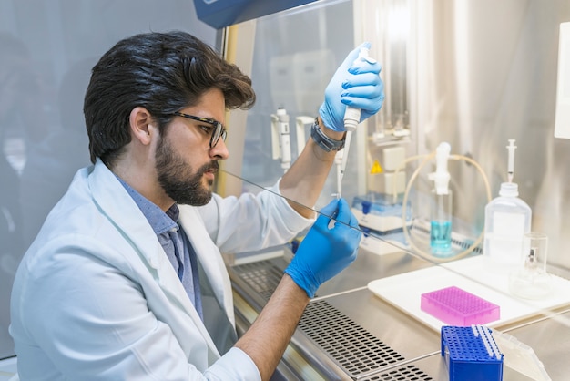 Él lleva a cabo experimentos en el laboratorio moderno.