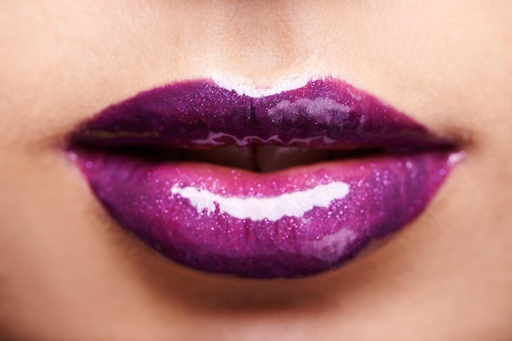 Foto lábios de mulher batom roxo e brilho com maquiagem e beleza closeup produtos cosméticos brilhantes e cosmetologia glow cor ousada estética e modelo feminino de cuidados cosméticos com brilho labial violeta