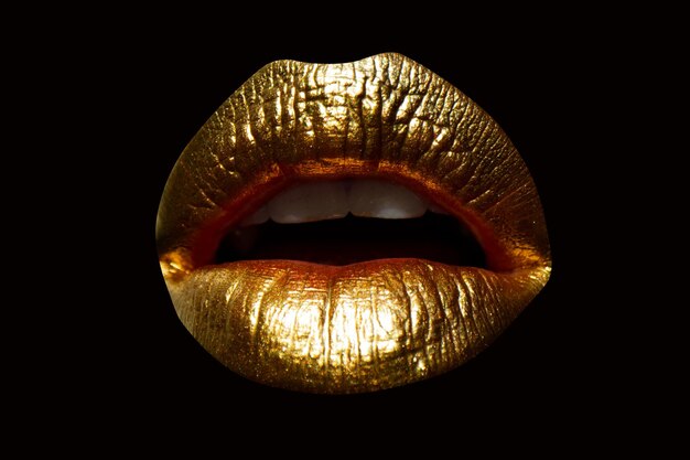 Labios dorados con lápiz labial dorado sobre fondo aislado Boca sensual de niña o mujer con oro