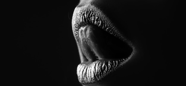 Labios dorados La mujer se cierra con lápiz labial de color dorado en el labio Brillo labios brillantes mordiendo