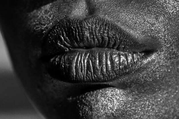 Lábios dourados ou dourados femininos sensuais no rosto como maquiagem ou arte corporal pintada de boca metalizada closeup
