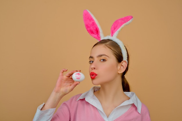 Labios y Pascua, Impresión de beso de lápiz labial en huevo de Pascua. Felices Pascuas. Mujer joven en orejas de conejo conejo.