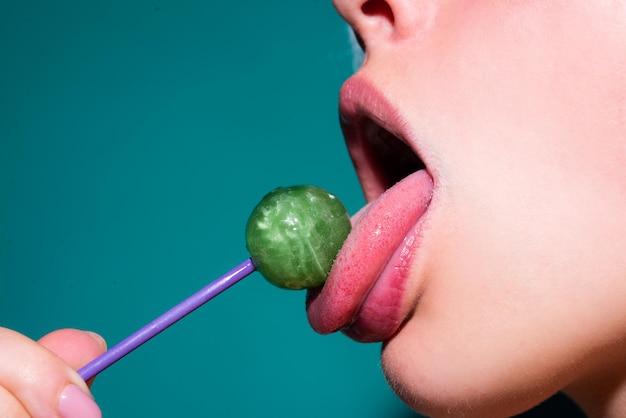 Labios sexuales con dulces, dulces sueños sexy. La boca femenina lame chupa chups, chupa piruleta.