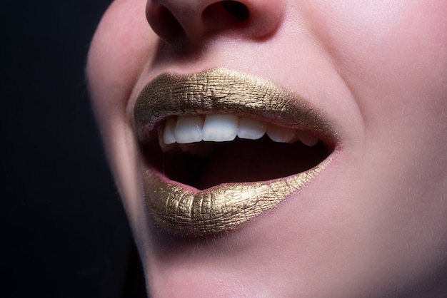 Lábios sorridentes closeup sexy lindos lábios dourados femininos isolado batom dourado