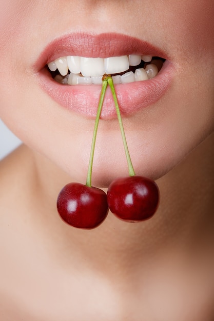 Lábios vermelhos sensuais com cereja isolado no branco