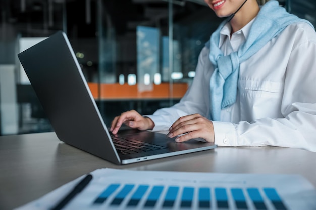 Laboral. Mujer joven que trabaja en la oficina y escribe en una computadora portátil