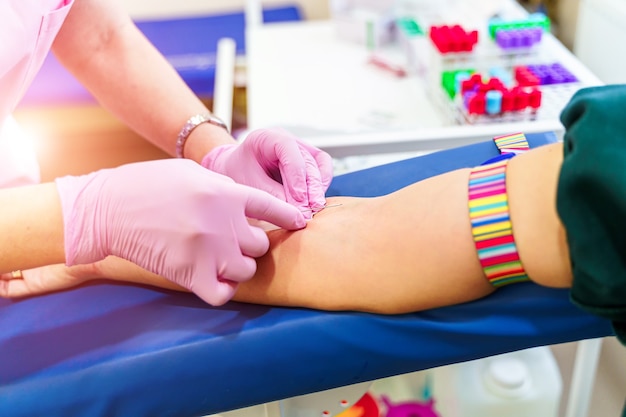 Laboratório com enfermeira colhendo amostra de sangue do paciente.