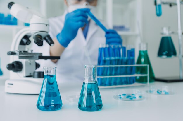 Laboratório de desenvolvimento médico Cientista feminina caucasiana olhando sob análises de microscópio Especialistas em amostras de placas de Petri trabalhando em pesquisa de biotecnologia médica em laboratório farmacêutico avançado