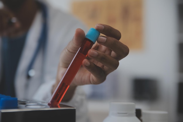 Laboratorio profesional Increíble trabajador médico de pelo largo que usa uniforme mientras usa microscopio durante la investigación