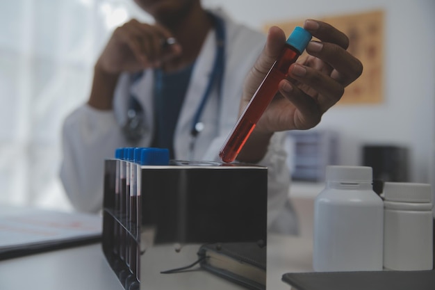 Laboratório profissional Incrível trabalhador médico de cabelos compridos vestindo uniforme enquanto usa microscópio durante a pesquisa