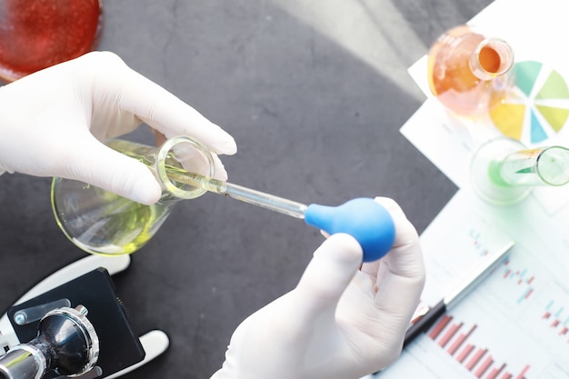 Laborforschung. Drogentest. Chemische Experimente im Labor. Mikroskopieren Sie verschiedene Reagenzgläser und Becher auf dem Tisch beim Amtsarzt.