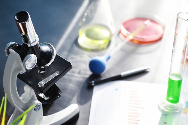 Laborforschung. Drogentest. Chemische Experimente im Labor. Mikroskopieren Sie verschiedene Reagenzgläser und Becher auf dem Tisch beim Amtsarzt.