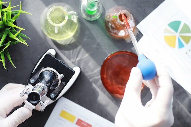 Laborforschung. Drogentest. Chemische Experimente im Labor. Mikroskopieren Sie verschiedene Reagenzgläser und Becher auf dem Tisch beim Amtsarzt.