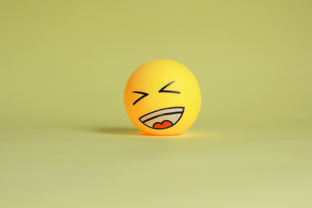 Lachen Emoticon lokalisiert auf gelbem Hintergrund