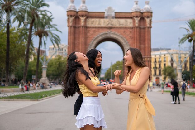 Lachen verschiedene Frauen in trendigen Outfits in der Stadt