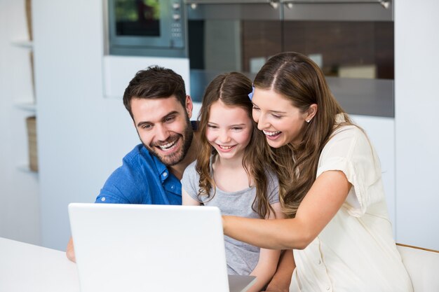 Lachende Familie beim Betrachten des Laptops