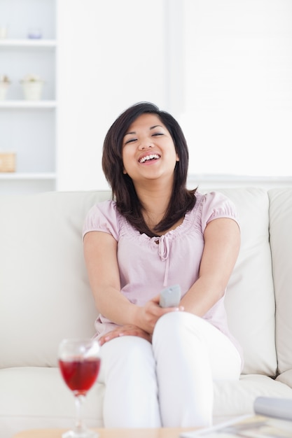 Lachende Frau beim Sitzen auf einem Sofa