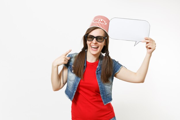 Lachende Frau in 3D-Brille mit Eimer für Popcorn auf dem Kopf beim Filmfilm, Zeigefinger auf sagen wir Wolke mit Platz für Text zeigend, Kopienraum einzeln auf weißem Hintergrund. Emotionen im Kino.