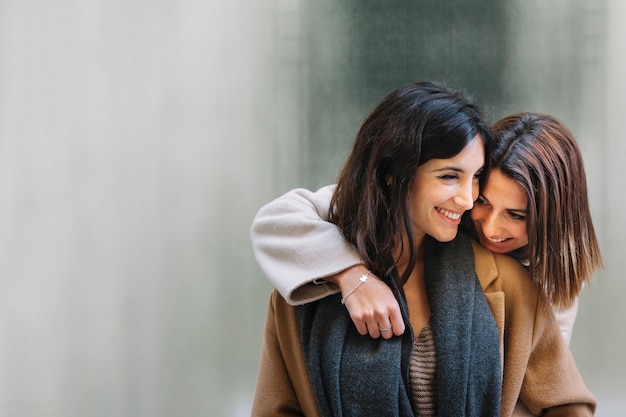 Foto lachende junge freundinnen, die in der liebe umarmen