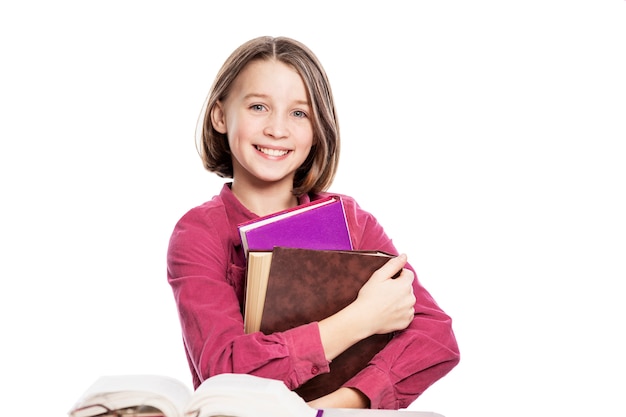 Lachende Mädchen Teenager in Gläsern sitzt an einem Tisch mit Büchern. Wissen und Bildung. .