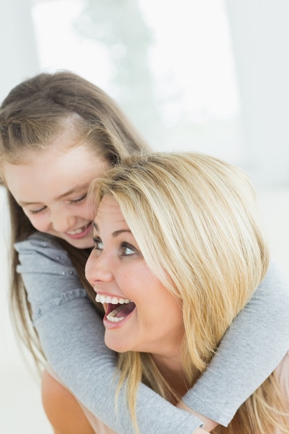 Lachende Mutter, die Tochter ein Doppelpol gibt