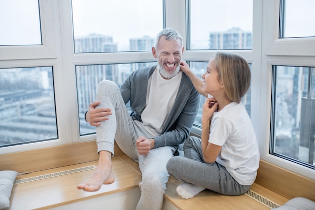 Lachender Mann und glückliches sprechendes Mädchen.