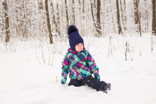 Lachendes Baby, das im Schnee spielt