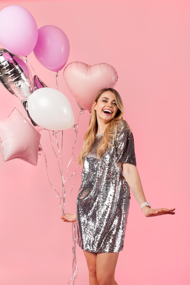 Lachendes Mädchen, das mit Luftballons posiert