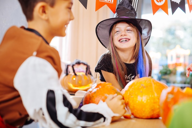 Lachendes Mädchen. Schönes lustiges Mädchen, das Zauberer-Halloween-Kostüm trägt, das während des Spielens laut lacht