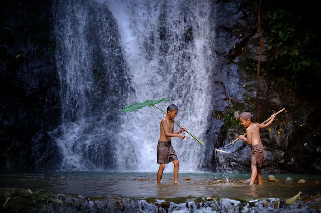 Lachenfischen mit zwei Jungen an einer Wasserfalllandschaft