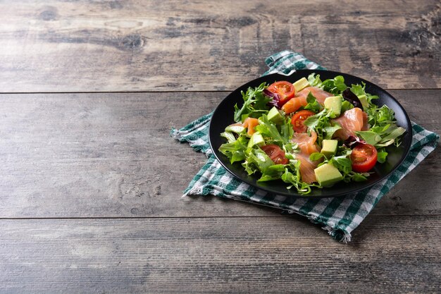Lachs-Avocado-Salat auf rustikalem Holztisch