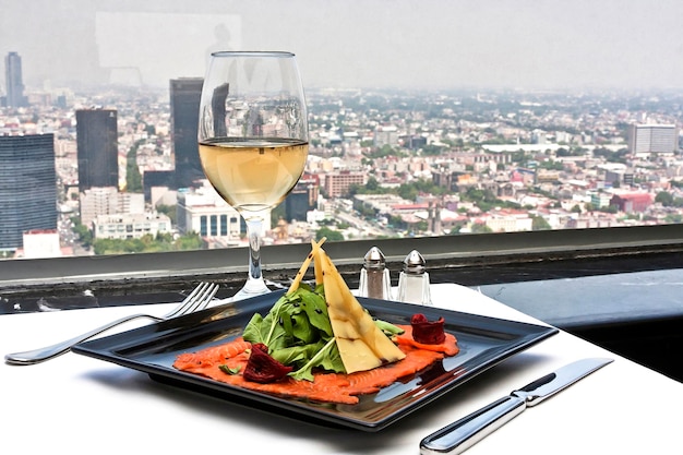 Lachs-Carpaccio mit Gouda-Käse und Rucola, serviert mit einem Glas Weißwein-Speisegetränk