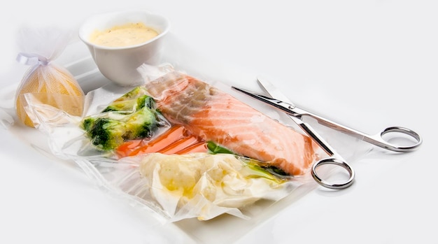 Lachs gekocht sous vide mit Gemüse auf weißem Hintergrund