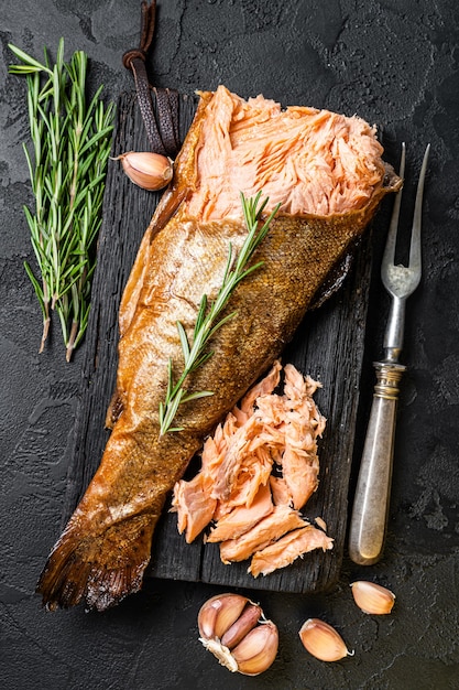 Lachs Heiß geräuchert, Forelle Fischfleisch. Schwarzer Hintergrund. Ansicht von oben.