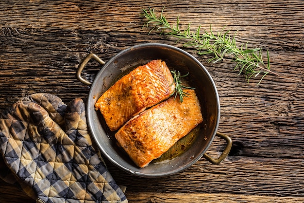 Lachs. Zwei saftige Lachssteaks im Bratentopf mit Kräuterdekor