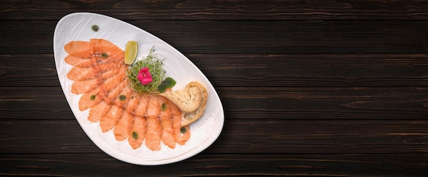 Lachscarpaccio mit Kalk und Brot auf einem hölzernen Hintergrund