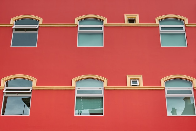 Lachsfarbene Hotelfassade mit symmetrischen Fenstern und Balkonen