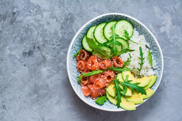 Lachssack mit Avocado, Rucola und Gurke in einer Schüssel. Ansicht von oben. Kopieren Sie Platz